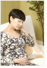 쇼파에 앉아 치통에 아파하는 여성